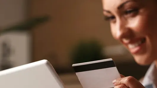 Frau mit Kreditkarte und Tablet in der Hand