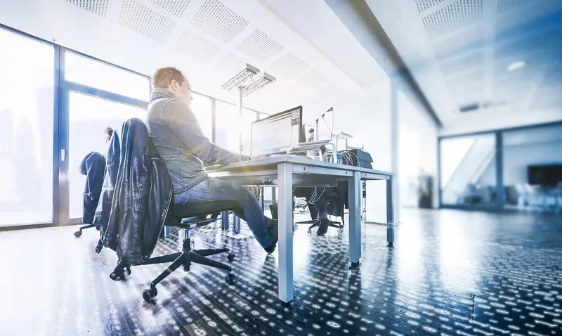 Person works at a desk with several monitors and evaluates digital tracking and analysis data for a website.