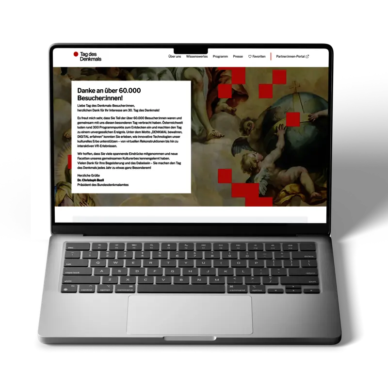Laptop mit geöffneter Webseite des Tags des Denkmals, gezeigt wird die Startseite mit Dankesbotschaft an über 60.000 Besucher:innen und Hintergrundmotiv eines historischen Gemäldes.