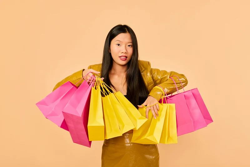 Person hält mehrere farbige Einkaufstaschen in den Händen – Symbol für modernes Online-Shopping, E-Commerce und erfolgreiche Verkaufsprozesse mit Shopify