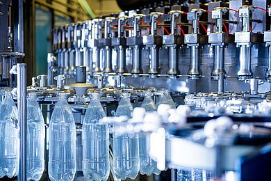 PET-Flaschen auf einer automatisierten Produktionslinie in einer Abfüll- und Verpackungsanlage der Kunststoffindustrie