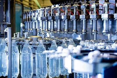 PET-Flaschen auf einer automatisierten Produktionslinie in einer Abfüll- und Verpackungsanlage der Kunststoffindustrie