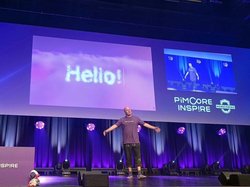Pimcore CEO Dietmar Rietsch eröffnet die Inspire 2025 Dietmar Rietsch auf der Bühne beim Opening der Pimcore Inspire 2025, vor großem „Hello!“-Slide und „Homecoming“-Branding