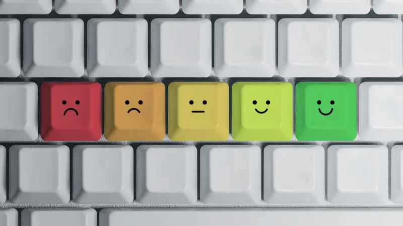 Bewertung der Website-Qualität und Nutzerzufriedenheit Tastatur mit farbigen Tasten von Rot bis Grün, die unterschiedliche Smiley-Gesichter von unzufrieden bis zufrieden zeigen und eine Bewertungsskala symbolisieren.