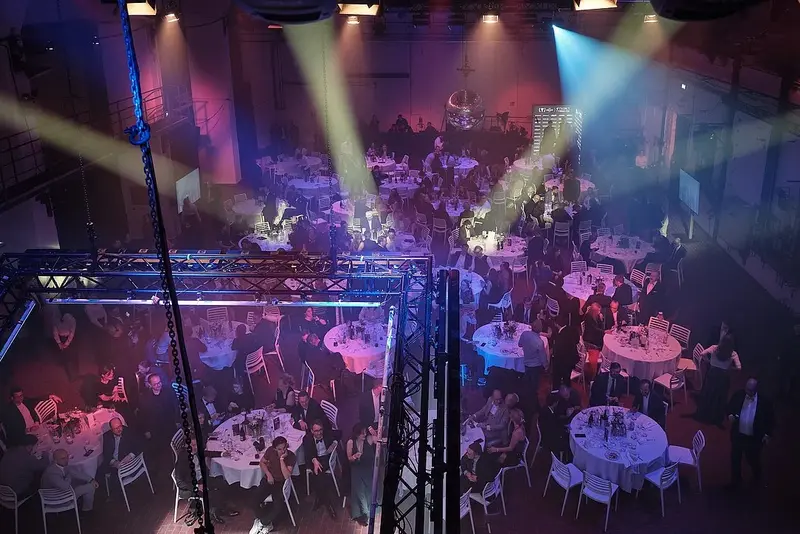 TYPO3 Award Gala 2025 - View over the ballroom Members of the band ‘Reggatta de Blanc’ stand on stage with a TYPO3 representative at the TYPO3 Award Gala 2025.