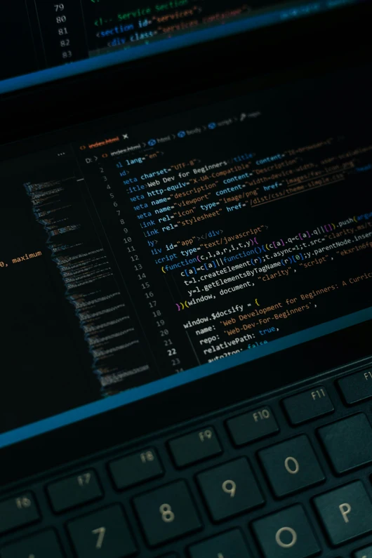 Ein geöffneter Laptop-Bildschirm zeigt Code in einem dunklen Texteditor, darunter HTML- und JavaScript-Syntax. Die Tastatur im Vordergrund ist leicht unscharf, während der Bildschirm scharf dargestellt ist. Die Szene vermittelt ein Gefühl von Softwareentwicklung und Open-Source-Programmierung.