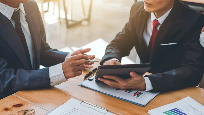 B2B-Vertrieb mit KI: Datenbasierte Entscheidungen im Vertrieb Besprechung von Vertriebskennzahlen und Geschäftsdaten auf einem Tablet. Das Bild steht für den Einsatz von künstlicher Intelligenz im B2B-Vertrieb zur Analyse von Kunden-, Produkt- und Marktdaten.