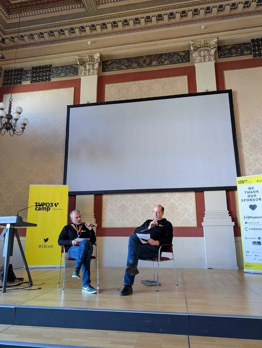Vortrag „TYPO3 15 – Die Zukunft kommt nicht von selbst!“ mit Jens Krumm und Matthias Hinner Jens Krumm und Matthias Hinner auf der Bühne des TYPO3Camp Vienna 2025 bei ihrer gemeinsamen Session