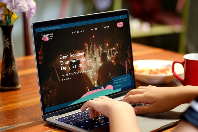 Startseite der Event-Website zum Sommernachtstraum im Olympiapark München Ein Laptop zeigt die Startseite der Sommernachtstraum-Website. Die Website präsentiert das Open-Air-Event mit großformatigem Bühnenmotiv, Navigation, Ticketzugang und Informationen zum Veranstaltungstag.