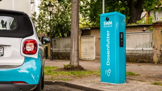 Electric car at a charging station belonging to Städtische Werke Magdeburg on the side of the road.