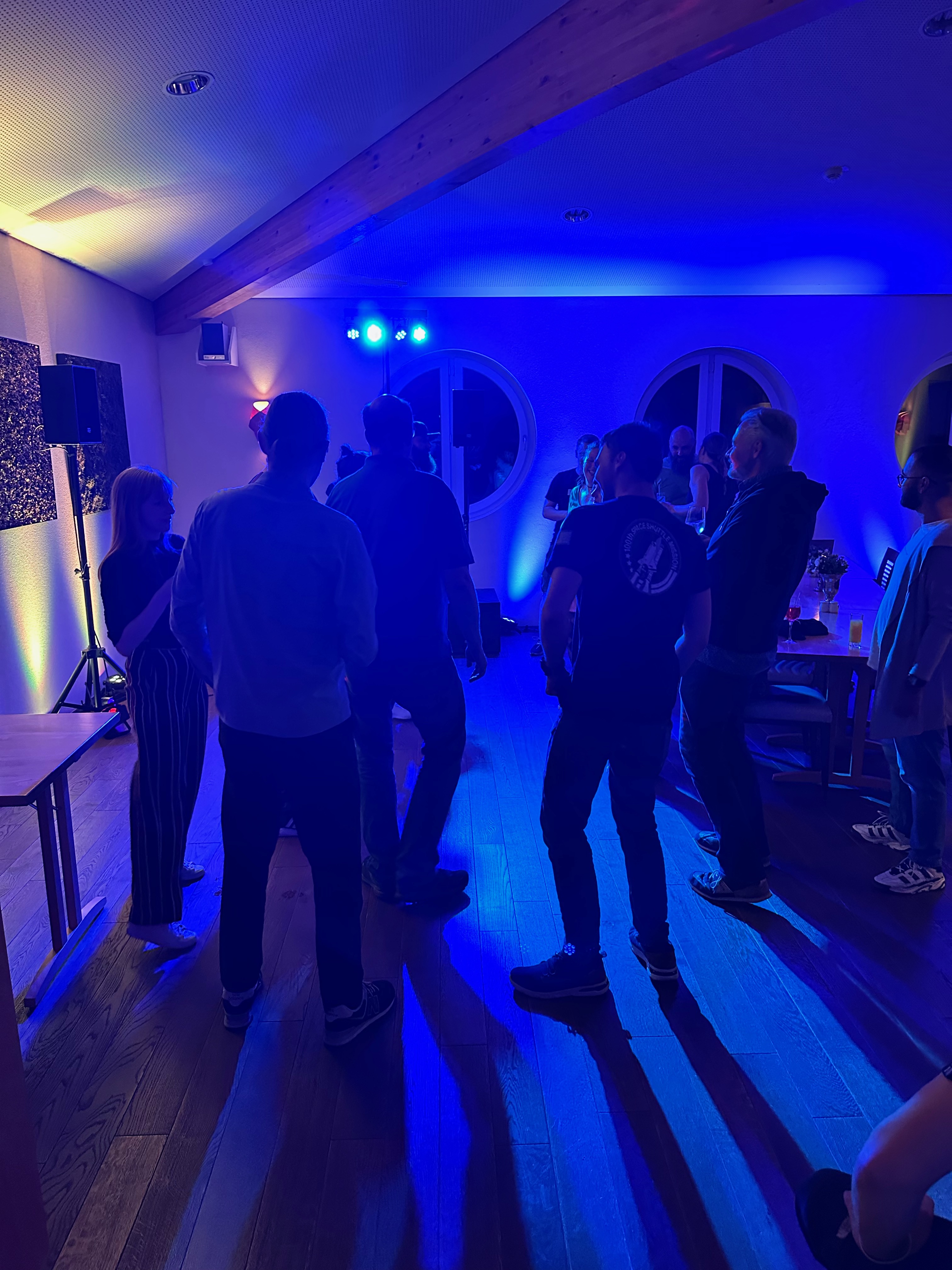 Pluscamp 2023 Partynight - glückliche +Pluswerker in der blau erleuchteten Innenraum-Disco